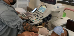 Radiology technician conduct a medical examination of a patient's neck using an ultrasound machine. With precision and expertise, they utilize the technology to capture detailed images, aiding in the diagnosis and treatment of the patient's condition. The technician proficiency ensures accurate and thorough assessment, contributing to optimal healthcare outcomes.
