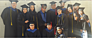 Photo of graduates adorned in caps and gowns.