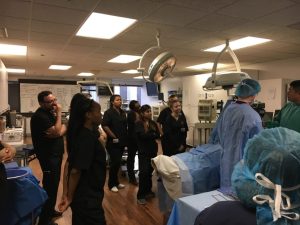 A group of CBD College students participating in a hands-on training session in a simulated operating room.