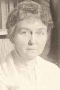 Susan Johnson, a founding member of the National Society for the Promotion of Occupational Therapy, stands confidently in a black-and-white photograph, exemplifying her dedication to the field of occupational therapy and education.