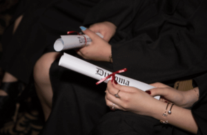 Image of female graduates holding their diplomas, celebrating their achievement with certificates in hand.