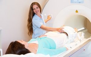 MRI technician explaining the scanning procedure to a patient before the MRI session.