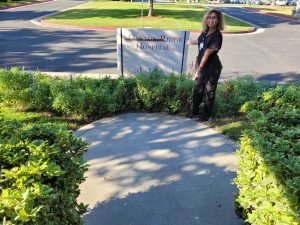 Corinne Ramaker, a graduate of the Occupational Therapy Assistant program at CBD College, stands proudly in front of the Canyon Ridge Hospital monument.